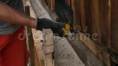 工人拆除木模板，为旧房子新建基础.. 工人用钢丝刀切割金属线